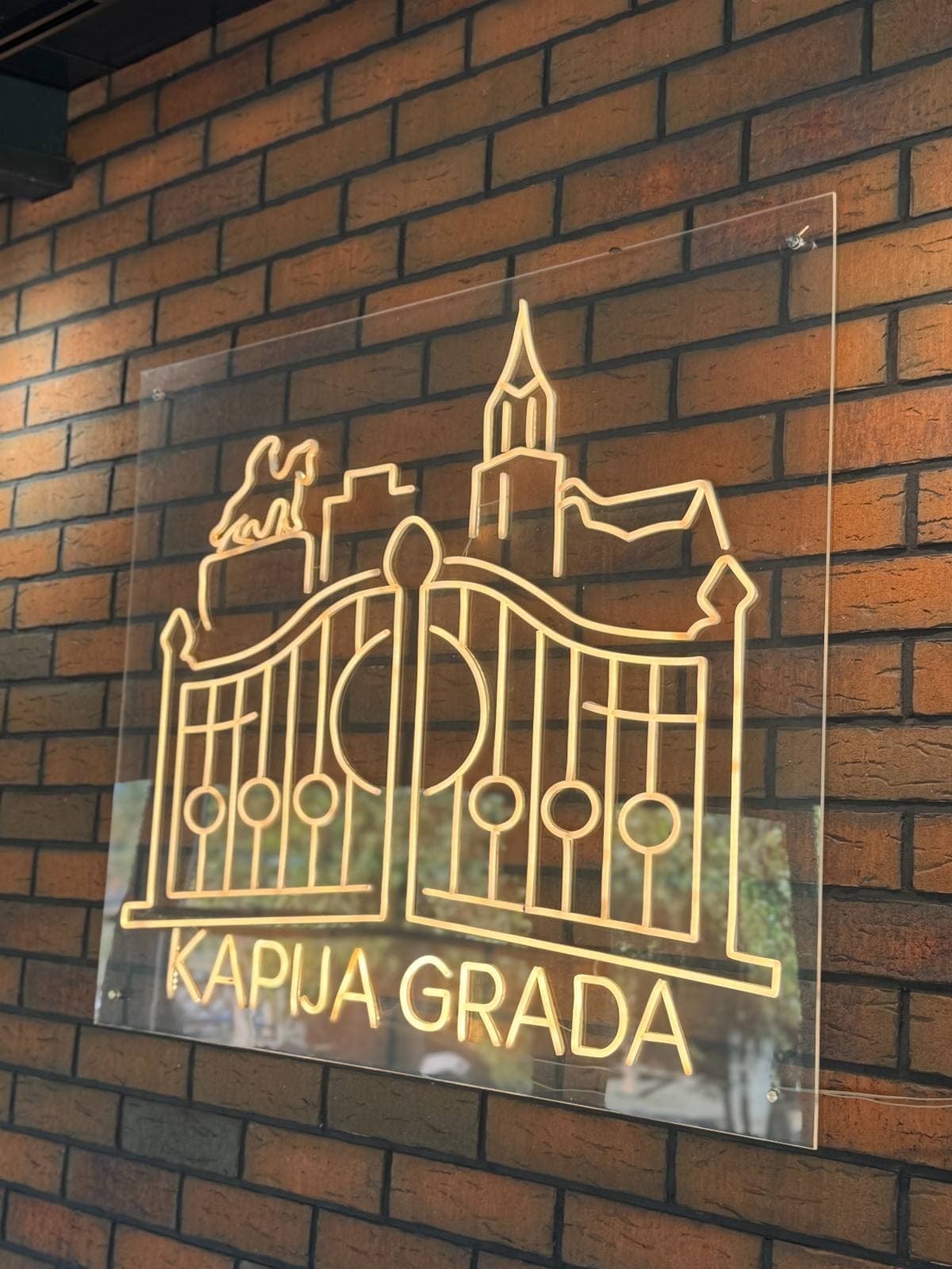 Svetleći znak Kapije grada na zidu od opeke